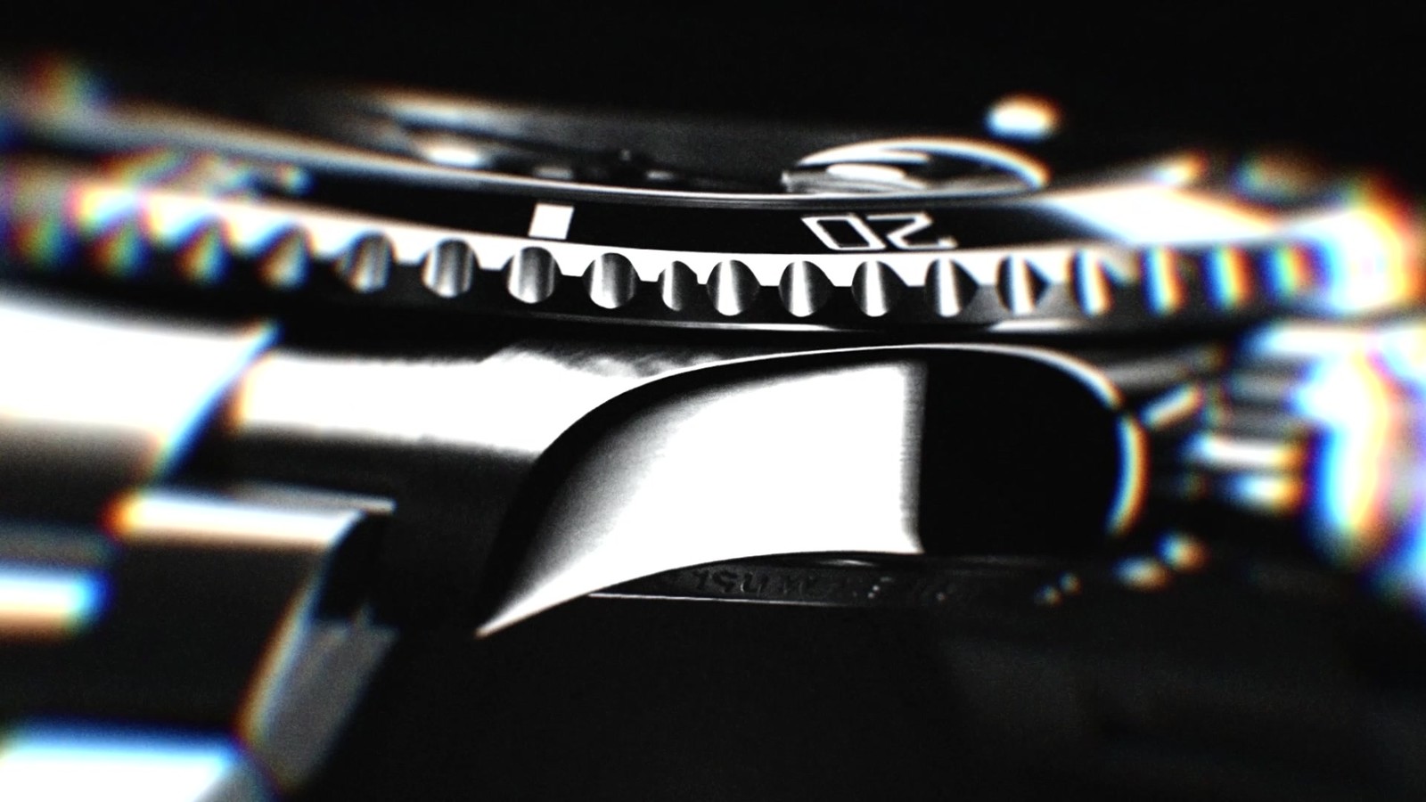 Plan 04 du film Rolex : macro de la glace cyclope et de la lunette crantée, franges chromatiques